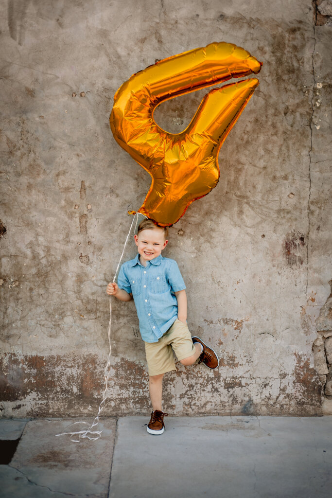 Family-Photos-Scorpion-Gulch-Phoenix-AZ-4 boy holding birthday balloon on back wall of Scorpion Gulch near South Mountain in Phoenix, AZ