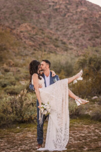 Arizona elopement photographer captures just wed Phoenix couple kissing in the middle of the desert.