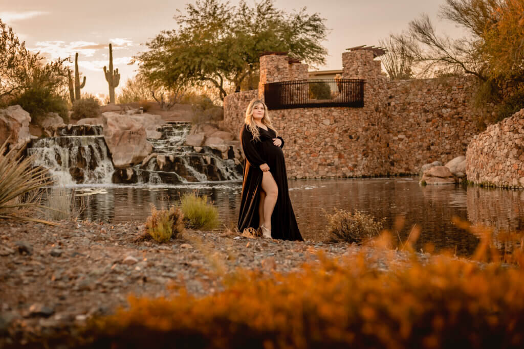 photo of pregnant woman at sunset with a waterfall and cactus background in Vistancia in Peoria, Arizona