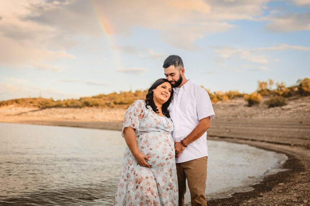 photo of maternity couple with rainbow in the sky at lake pleasant in Arizona