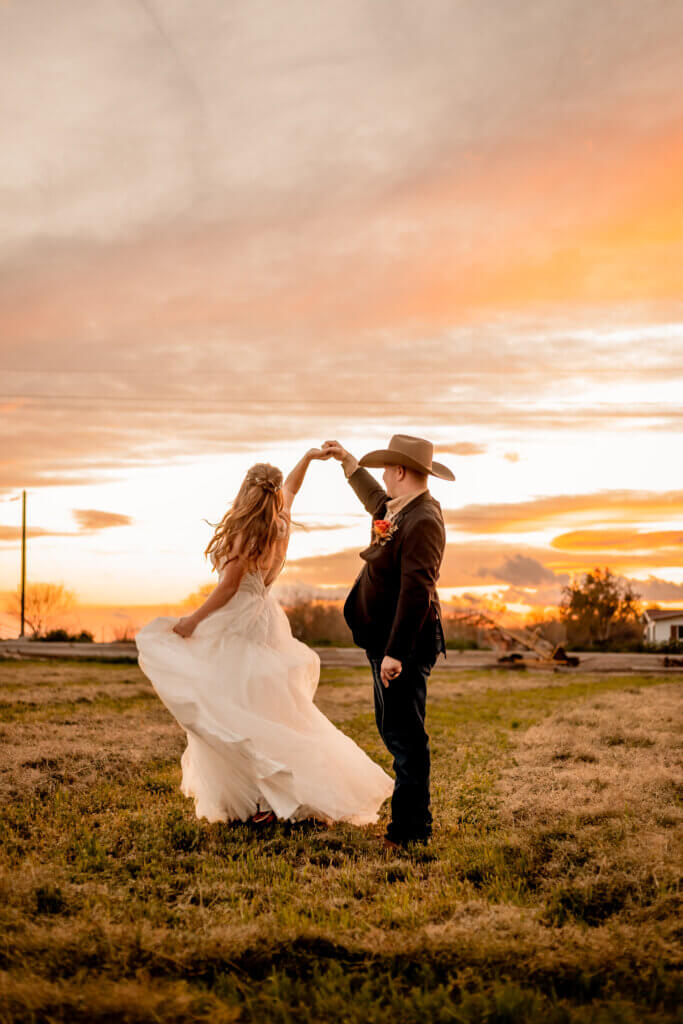 silhouette photo of bride and groom dancing at sunset