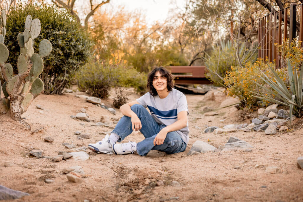 photo of senior boy sitting in desert wash