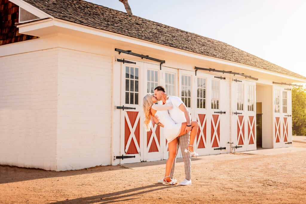 couple anniversary photo of man dipping wife in front of barn photo at Sahuaro Ranch Historic Park in Glendale, AZ