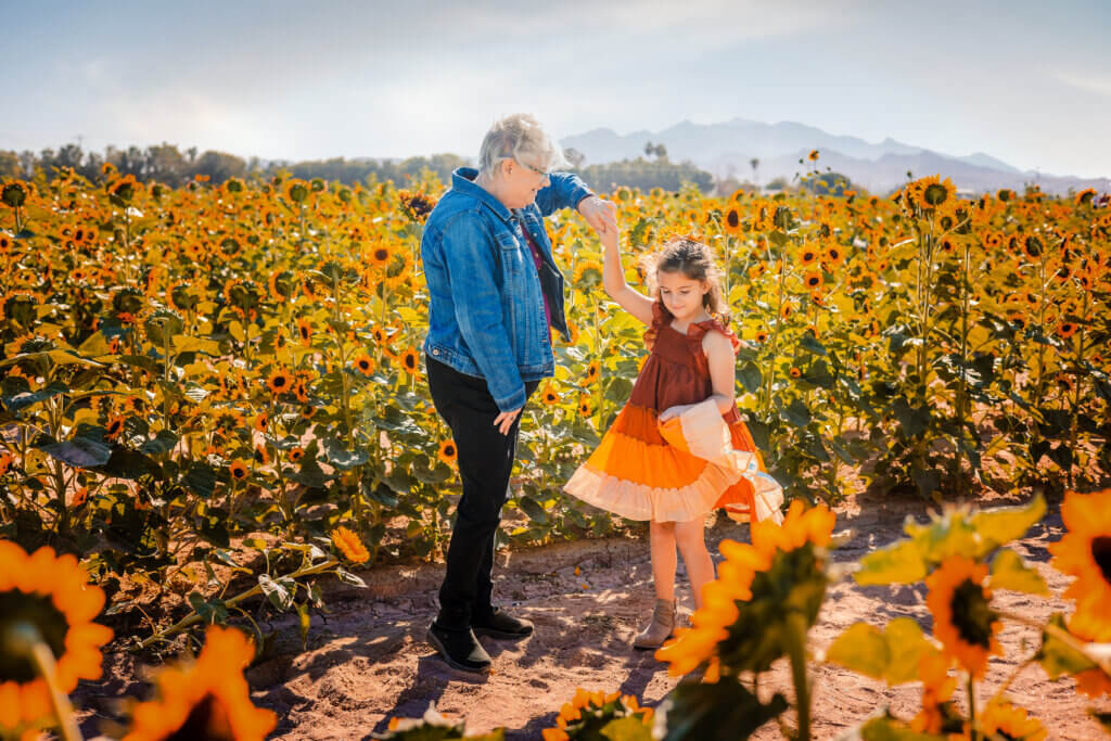 photo with grandmother twirling granddaughter in the sunflower field at Rocker 7 Farm in Buckeye, Arizona