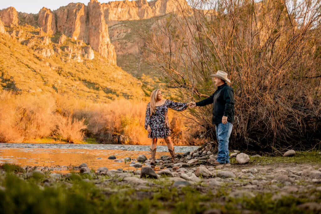 Photo of engaged couple near the rocks and cliffs of the Salt River with water