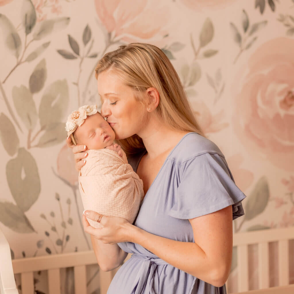 photo of mom kissing baby girl in-home lifestyle newborn session