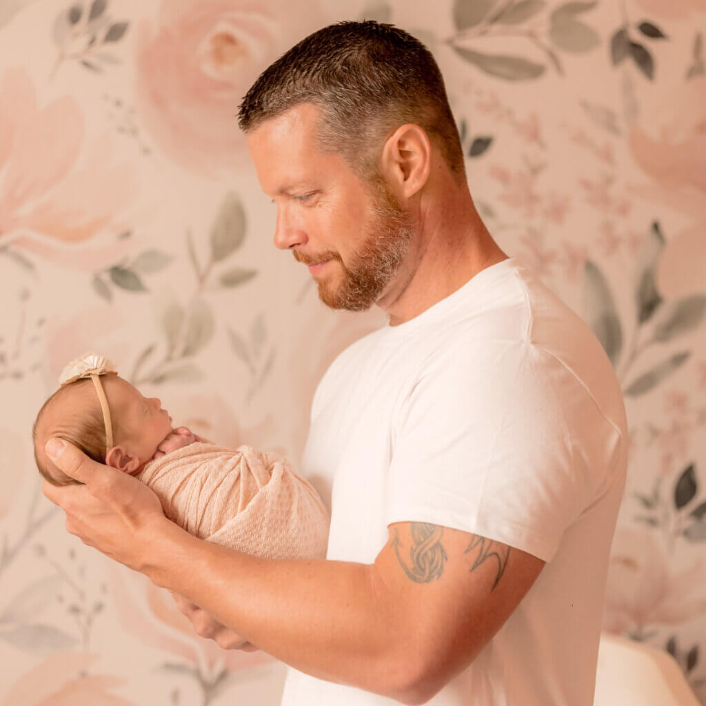 photo of dad looking at baby girl in-home lifestyle newborn session