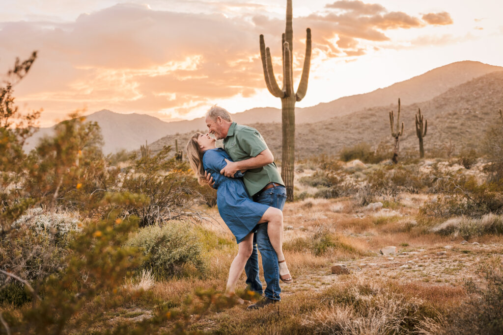 photo of couple going in for a dip with the golden mountains and background at sunset
