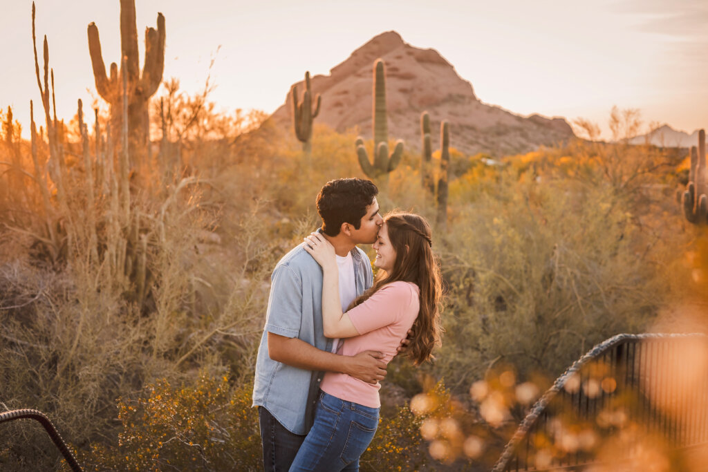 photo of engagement couple and Papago Red rocks, and desert, and cactus with the golden sun background at the Desert Botanical Gardens