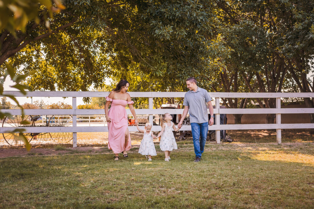 Phoenix family walking at green location for family photography session at Manistee Ranch in Glendale, Arizona.