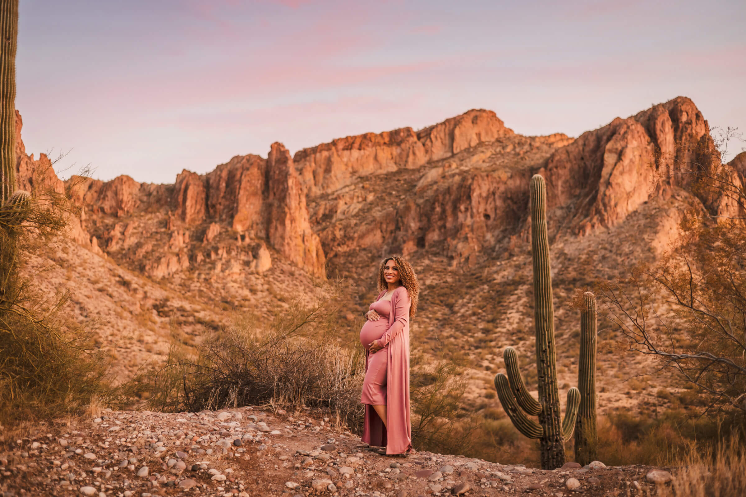 Expecting mother standing against a desert backdrop during a maternity photography session near Phoenix’s Salt River.