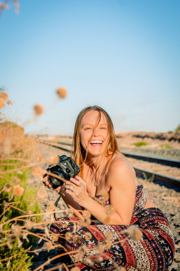 Photo of Candace Weir holding a camera, Photographer and owner of Memories by Candace, specializes in family, maternity, newborn, wedding, senior, and engagement photos in Phoenix.