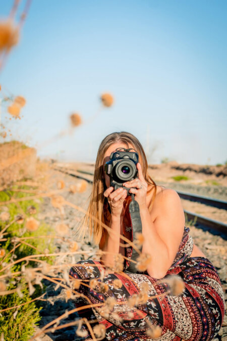 Photo of Candace Weir holding a camera, Photographer and owner of Memories by Candace, specializes in family, maternity, newborn, wedding, senior, and engagement photos in Phoenix.