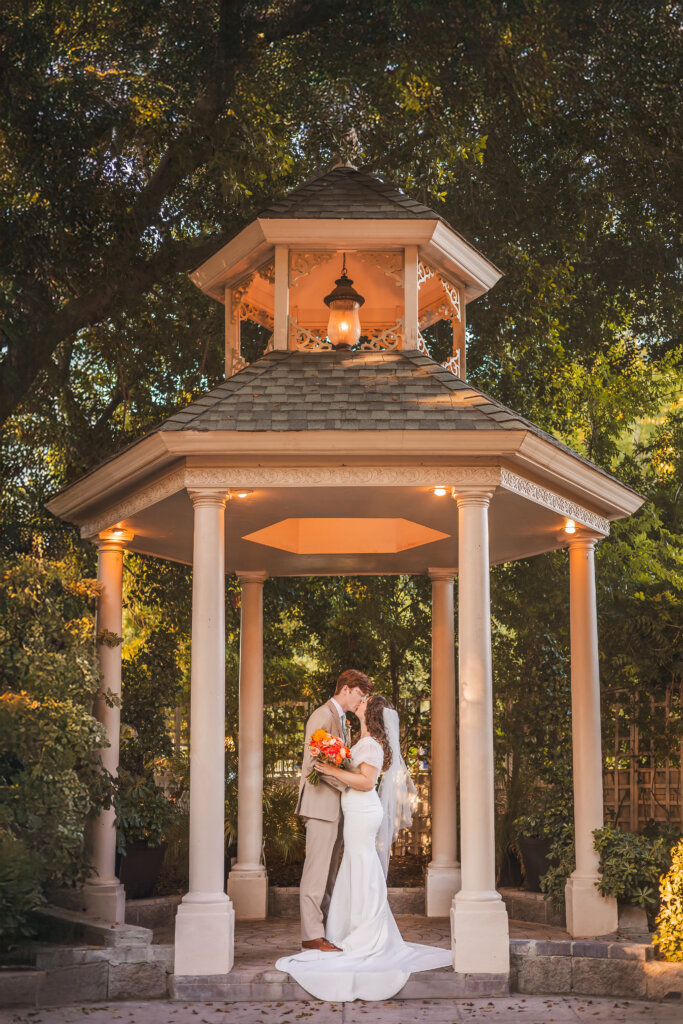 Wedding photo of couple standing under a gazebo at the Wright House wedding venue in Mesa, Arizona.
