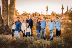 Family photo in the desert with golden light in the background during winter of December, with cooler temperatures to have layers in clothing.