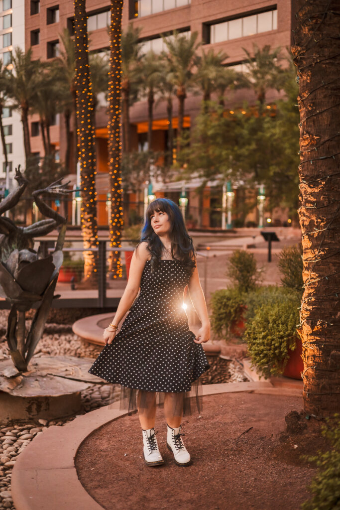 Candid senior portrait with glowing evening lights in downtown Phoenix.
