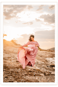 Wind blown dress and hair of pregnant woman during maternity photoshoot near Lake Pleasant, captured by Phoenix photographer.