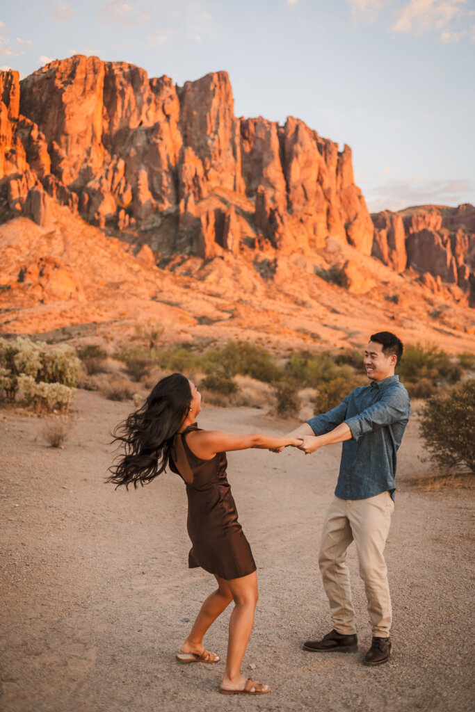 Phoenix-Engagement-Photographer-99 Couple spinning around and being playful for candid moments with Phoenix engagement photographer at the Superstition Mountains.