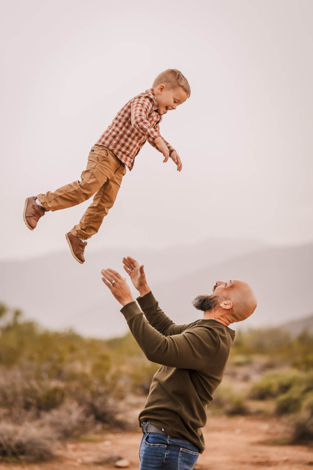 Father tossing his son into the air during a Phoenix family photography session