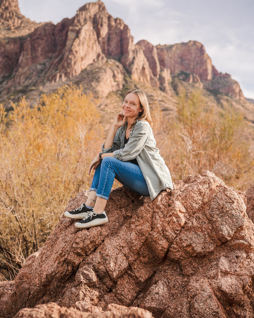 Phoenix photographer, Candace Weir, sitting on a rock in the desert.