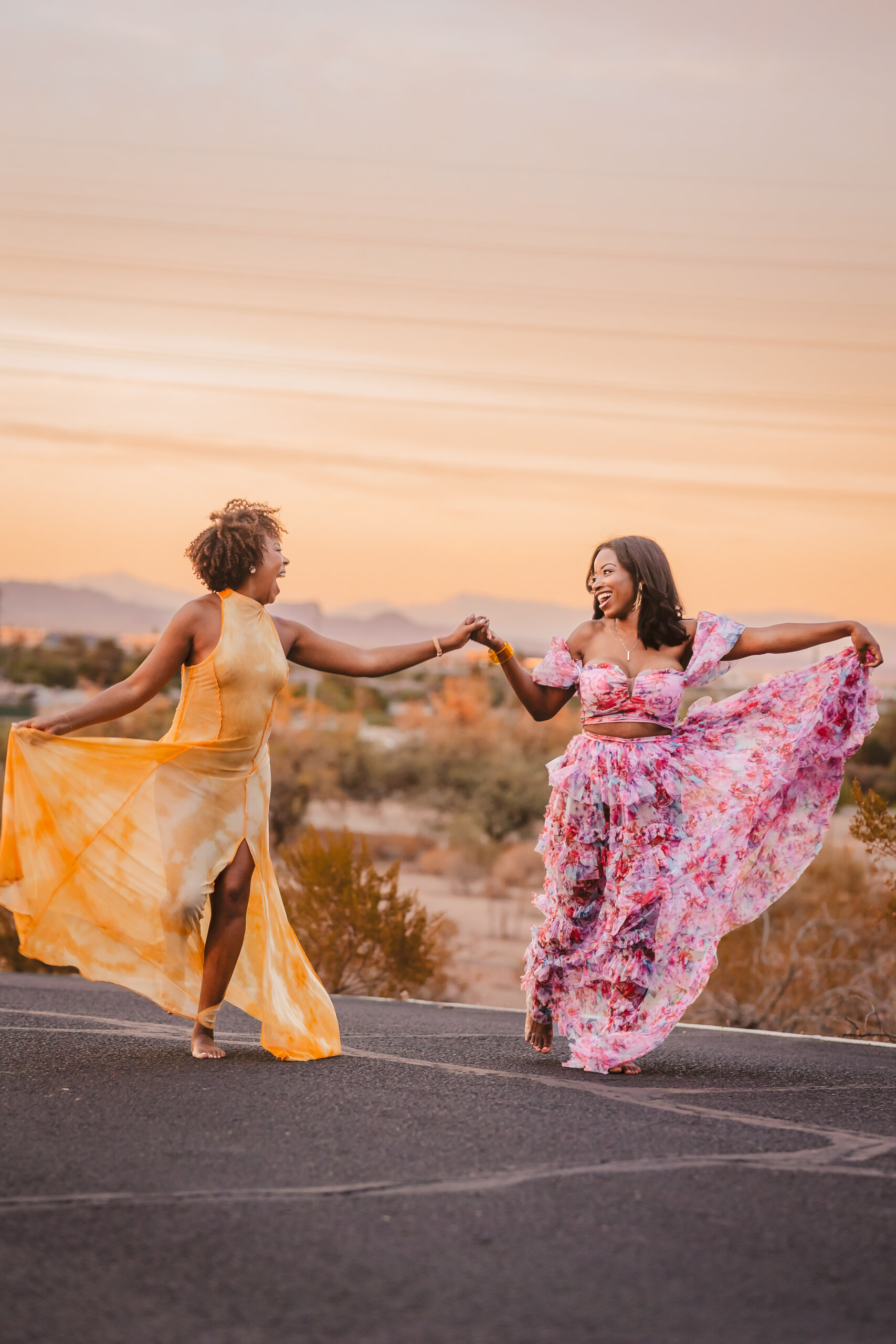 Two women laughing and dancing during a joyful portrait session
