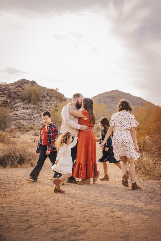 photo of children running around their parents in the desert during family photography session