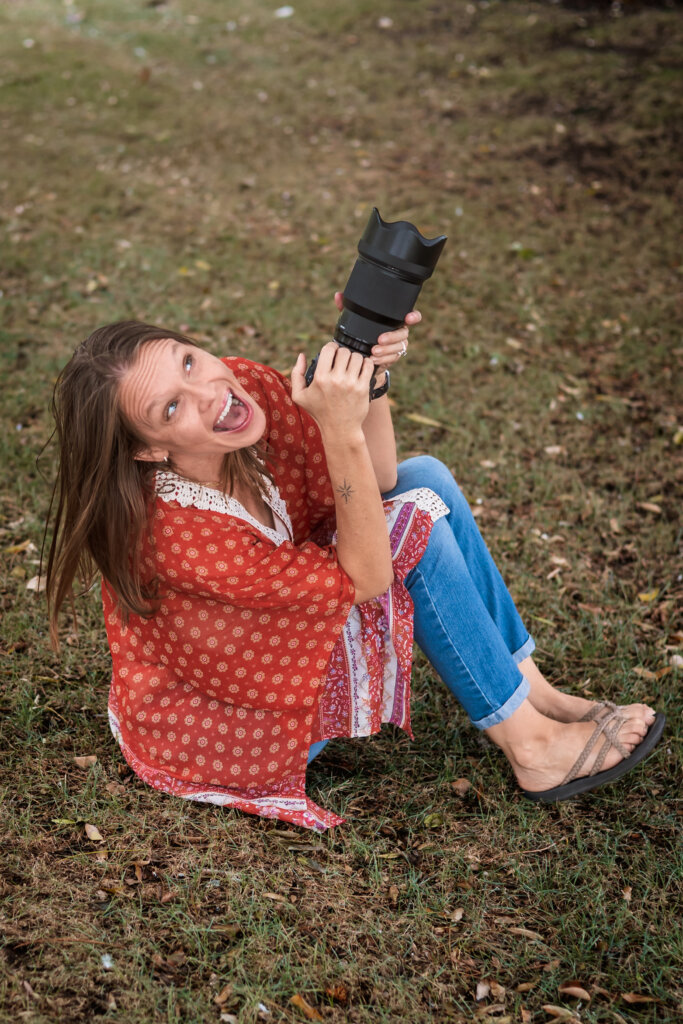 Phoenix photographer, Candace Weir of Memories by Candace, holding camera and looking up for a fun photo, showing her friendly and bubbly personality and reasons to create photographs.